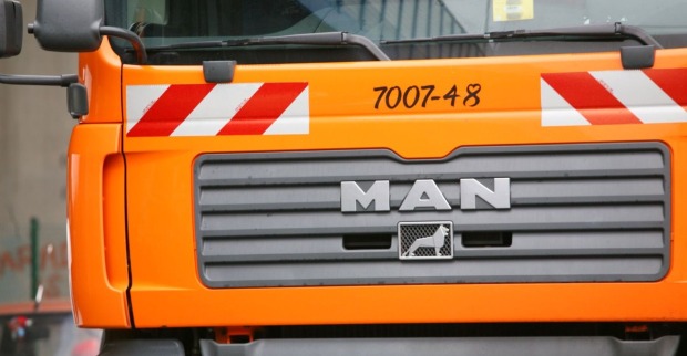 Orangefarbener Müllwagen der Stadt Wien, Nahaufnahme der Frontpartie mit MAN-Logo.