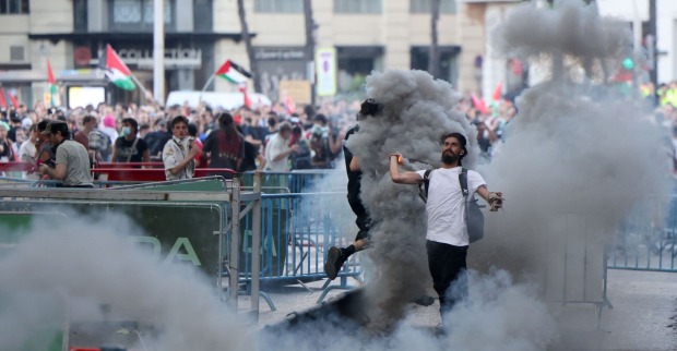 Ein Demonstrant wirft eine Rauchfackel, nachdem pro-palästinensische Protestierende während der 21. und letzten Etappe der Vuelta die Strecke blockierten.