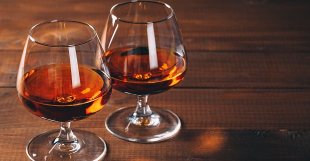 Zwei Cognac-Gläser auf einem Holztisch