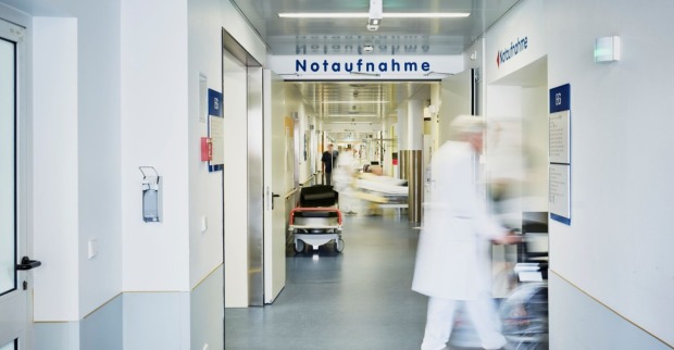 Notaufnahme eines Krankenhauses mit medizinischem Personal und Tragen auf einem Flur, aufgenommen in einer österreichischen Klinik.