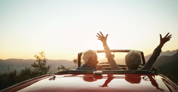 Zwei ältere Menschen sitzen in einem Cabrio
