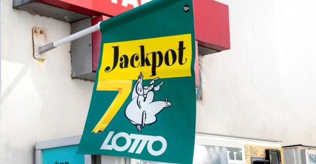 Grünes Lotto-Schild mit der Aufschrift „Jackpot 7“ und Cartoon-Schwein, Symbol für den Millionen-Jackpot.