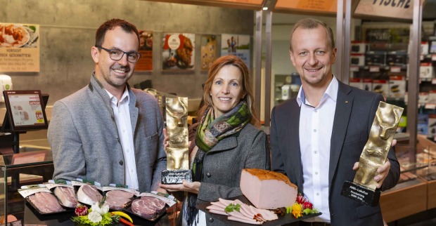 Drei Menschen lächeln in die Kamera