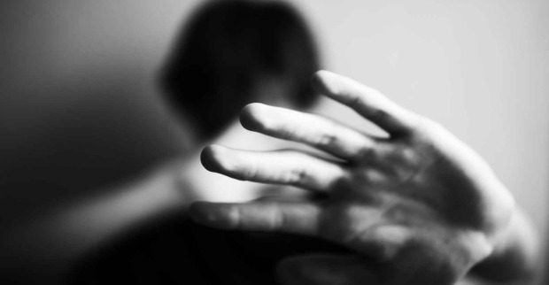 Ein Mann schützt sich sein Gesicht mit der Hand