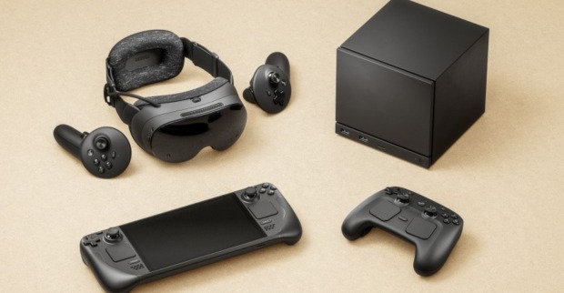 Schwarze Steam-Machine-Hardware auf hellem Untergrund: kompakte Konsolenbox, VR-Headset mit zwei Controllern, Steam-Handheld und neuer Steam Controller.