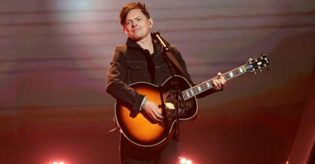 Ein Mann mit Gitarre steht auf der Bühne