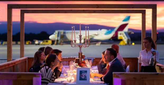 Mehrere Menschen dinieren vor einem Flugzeug