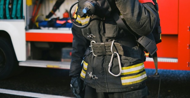 Feuerwehrmann in Uniform vor Wagen
