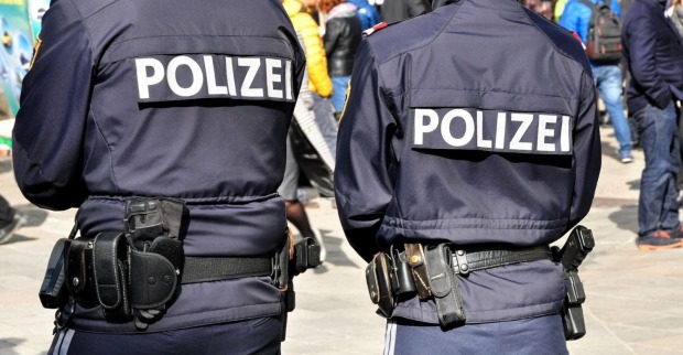 Zwei Polizisten patrouillieren in Uniform auf einer Straße