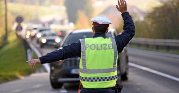 Ein Polizist der Autos aus dem Verkehr zur Umleitung hinweist.