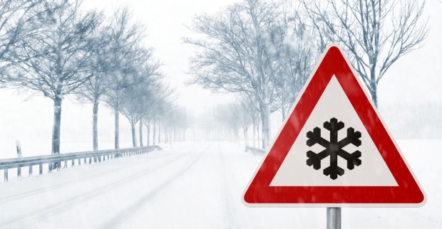 Verkehrstafel auf einer verschneiten Fahrbahn.