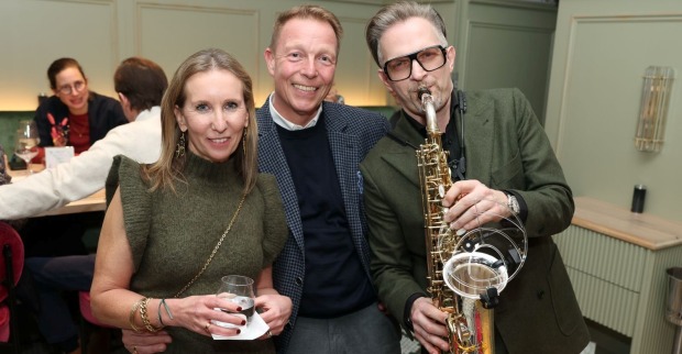 Frau  mit Wasserglas, Mann im karierten Sakko und ein Saxophonist