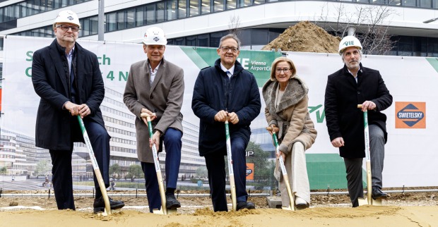 Fünf Personen mit Spaten bei der Flughafenbaustelle