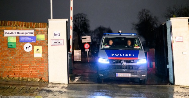 Ein Polizeifahrzeug steht am Eingang des Friedhofs Baumgarten in Wien-Penzing bei Nacht, wo eine Frau erstochen wurde.