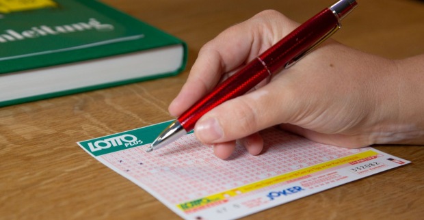 Hand füllt Lotto-6-aus-45-Schein mit rotem Stift aus – Wiener gewinnt bei Lotto-Ziehung 6,1 Millionen Euro im Fünffach-Jackpot.