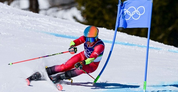 Skirennläuferin Julia Scheib in rotem Rennanzug fährt beim olympischen Riesentorlauf in Cortina d’Ampezzo durch ein Tor auf schneebedeckter Piste.