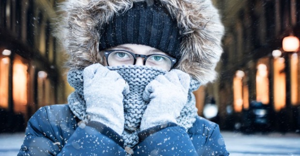 Frau, die in einer verschneiten, kalten Wiener Innenstadt steht