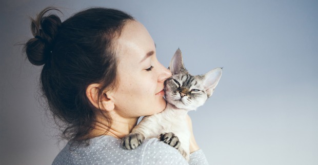 Junge Frau kuschelt mit ihrer Katze | Credit: iStock.com/insonnia