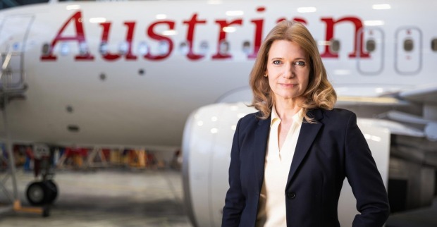 Frau im dunklen Blazer vor einem Flugzeug