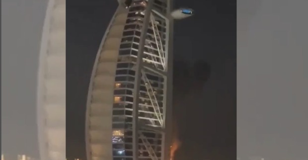 Das brennende Burj Al Arab Hotel in Dubai bei Nacht nach einem Drohnenangriff mit sichtbaren Feuersäulen an der Fassade
