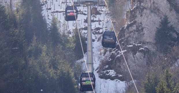 Gondelbahn im Skigebiet Engelberg-Titlis in der Schweiz mit mehreren Kabinen vor verschneitem Berghang