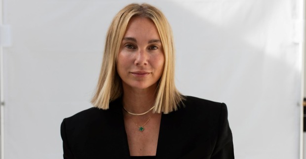 Eine Frau im schwarzen Blazer schaut in die Kamera