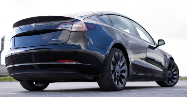 Tesla Model 3 von hinten auf der Straße mit Fokus auf Design und Karosserie, Symbol für wachsende Konkurrenz durch chinesische Elektroautos