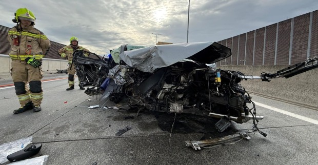 Ein völlig zerstörtes Auto steht nach einem schweren Verkehrsunfall auf der S1 bei Korneuburg auf der Fahrbahn, während Feuerwehrkräfte die Unfallstelle sichern.