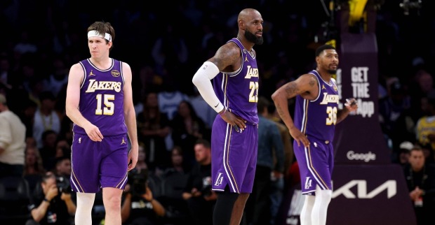 Austin Reaves, LeBron James und Marcus Smart von den Los Angeles Lakers beobachten das Spiel gegen die Houston Rockets im vierten Viertel von Spiel fünf der ersten Runde der NBA-Playoffs in der Western Conference.