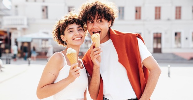 junger Mann und junge Frau in weißen Shirts und mit Eistüten