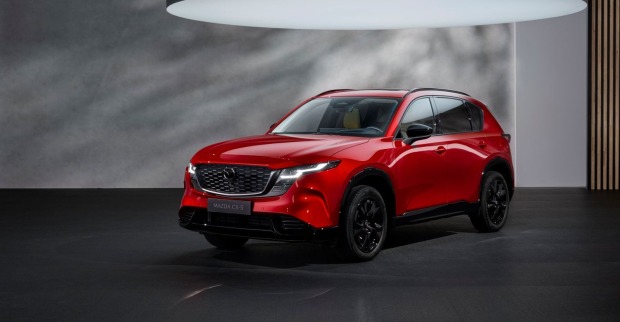 Eine roter Mazda CX 5 steht einem grau-schwarzen Raum. Über dem Auto ist ein sehr großes Licht zu sehen, das das Auto beleuchtet.