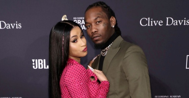 Offset und Cardi B. posieren gemeinsam auf einem Event vor einer dunklen Fotowand, beide blicken in die Kamera./ Offset wurde angeschossen