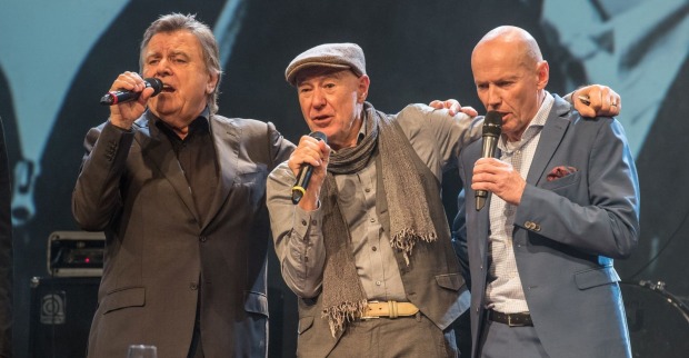 Peter Resetarits gemeinsam mit Willi Resetarits auf der Bühne bei einem emotionalen Konzertauftritt mit Mikrofonen
