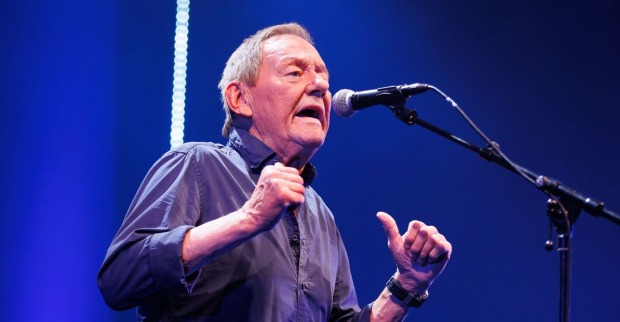 Wolfgang Ambros singt live auf der Bühne mit Mikrofon während eines Konzerts