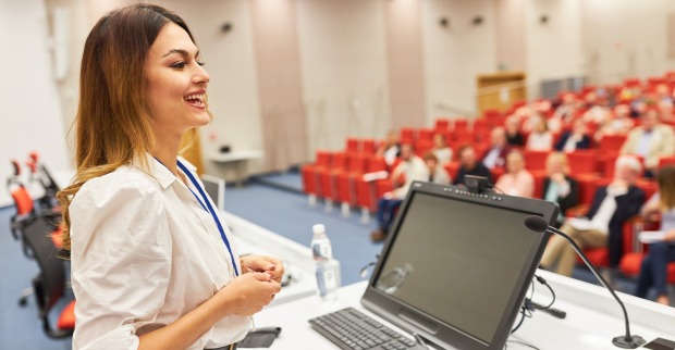 Junge Frau referiert im Hörsaal | Credit: Robert Kneschke/Shutterstock