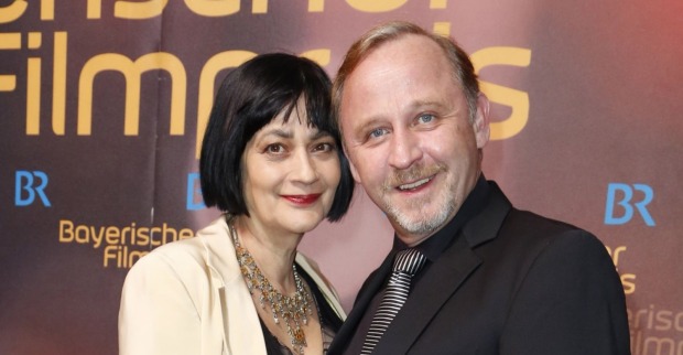 Alexander Held mit Ehefrau Patricia bei Filmpremiere, beide lächelnd nebeneinander, vor Event-Hintergrund