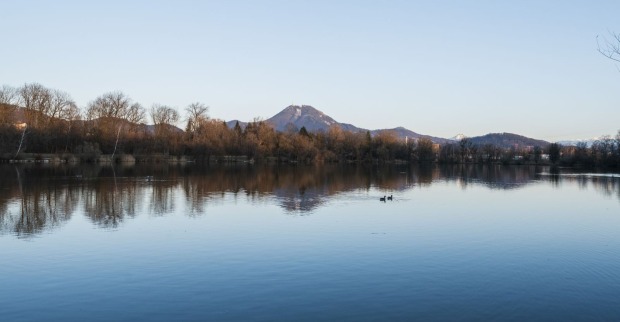Ein See, dahinter ist ein Berg zu sehen
