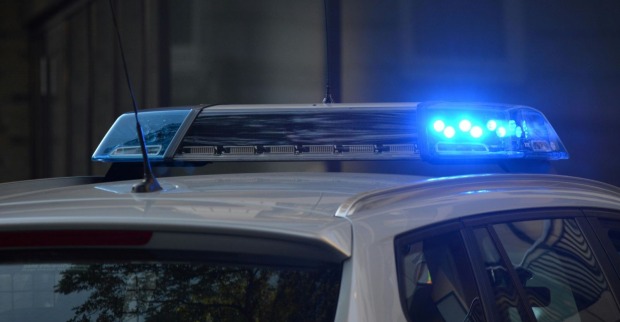 Polizeiauto mit blauem Blaulicht bei nächtlichem Einsatz.