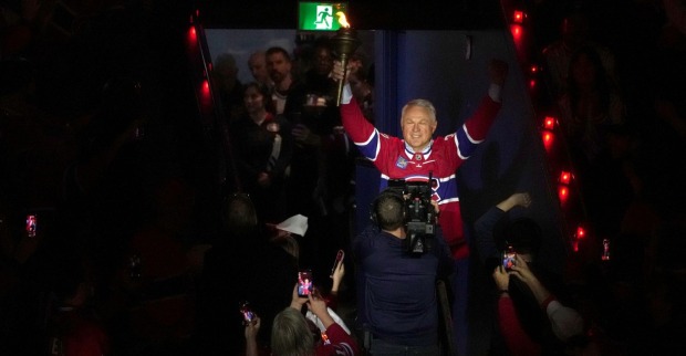 Der ehemalige Eishockey-Profi Claude Lemieux hebt lächelnd die Hände auf dem Eis bei einer Ehrung