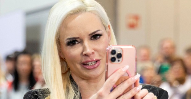 Daniela Katzenberger blickt kritisch auf ihr Smartphone und spricht offen über ihre Erfahrungen mit der Promiwelt und dem Showbusiness.