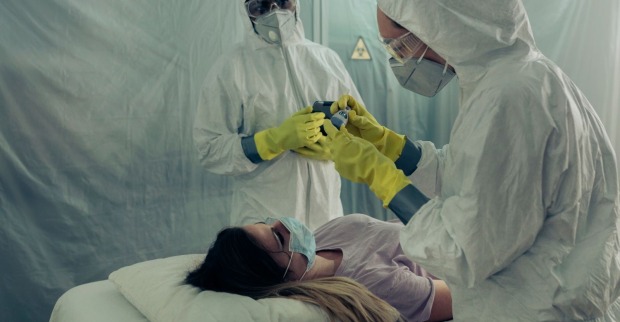 Medizinisches Personal in Schutzanzügen untersucht Patientin bei Ebola-Verdachtsfall unter strengen Sicherheitsmaßnahmen