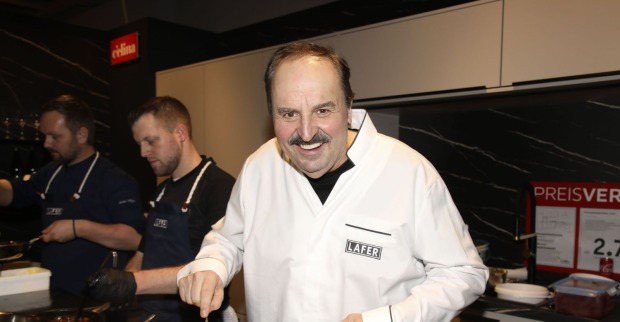 Johann Lafer kocht in weißer Kochjacke trotz Lymphdrüsenkrebs und Chemotherapie in einer Küche