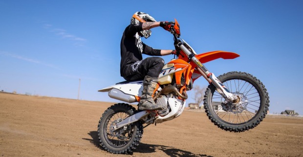 KTM Enduro Motorrad im Gelände mit Fahrer bei Wheelie Symbolbild für Alibi Zulassung und entdrosselte Motorräder