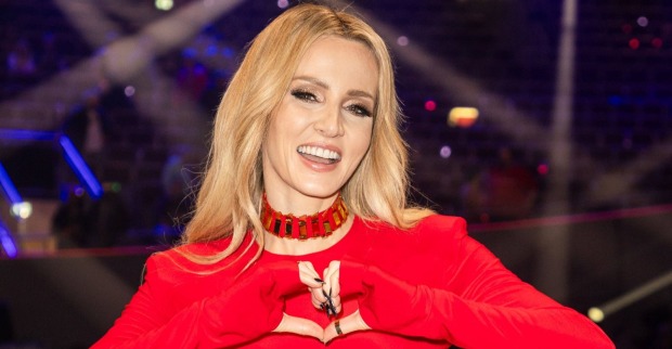Melissa Naschenweng in rotem Outfit bei einem Event – die Sängerin lächelt in die Kamera und formt mit den Händen ein Herz.