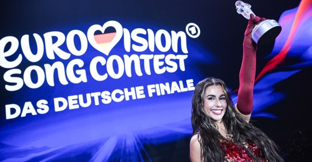 Eine Frau hebt lachend eine Trophäe in die Höhe