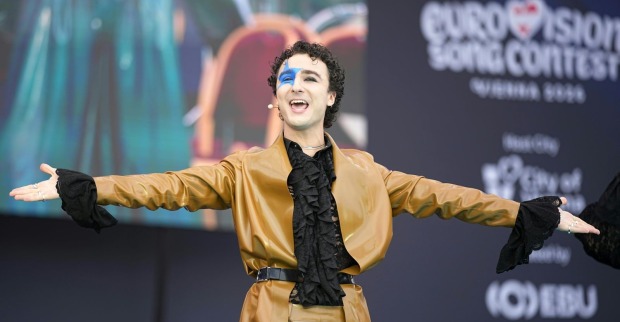 Ein Mann mit blauem Stern im Gesicht streckt die Arme aus