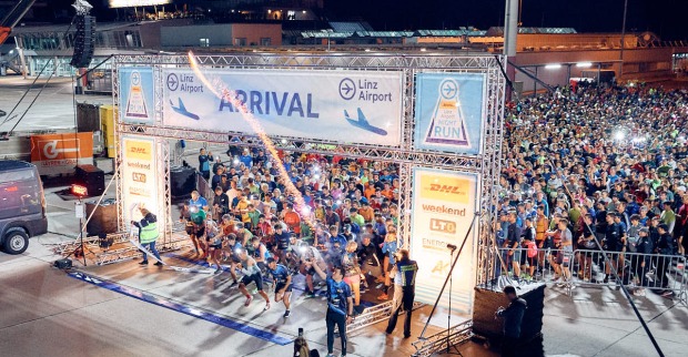 Start des 10. DHL Linz Airport Night Run am Flughafen Linz mit zahlreichen Läuferinnen und Läufern bei Nacht.