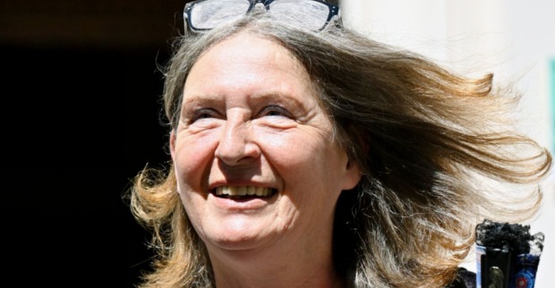 Elke Kahr lächelt bei einem öffentlichen Auftritt in Graz, ihre Haare werden vom Wind bewegt, eine Brille liegt auf ihrem Kopf.