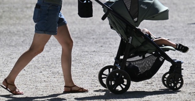 Eine Frau mit einem Kinderwagen.