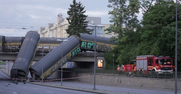 Ein abgestürzter Güterzug hängt von einer Brücke